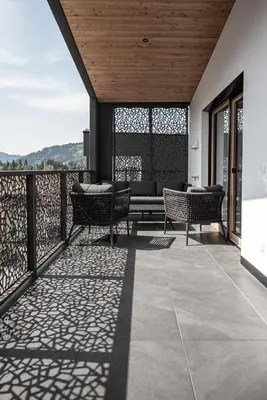 a patio with chairs and a couch on a balcony at Luxury Penthouse - Between Kronplatz, 3 Peaks Dolomites and Lake Prags in Monguelfo