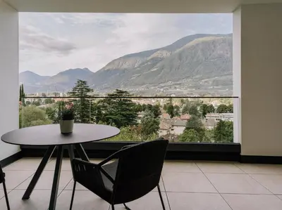a table and chairs in a room with a large window at The Hills in Merano