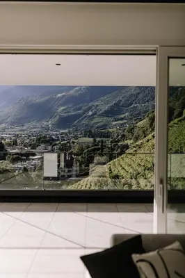 a room with a large window with a mountain view at The Hills in Merano