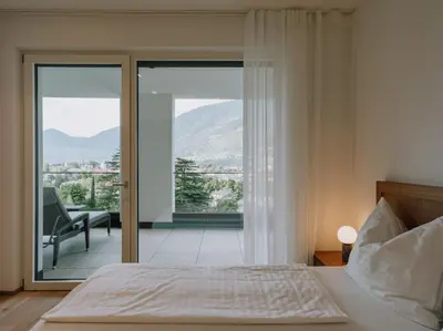 a bedroom with a bed and a view of a balcony at The Hills in Merano