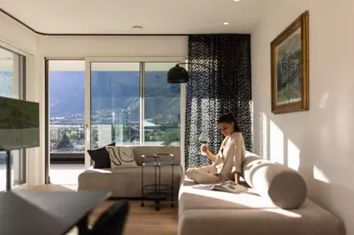 a woman sitting on a couch in a living room at The Hills in Merano