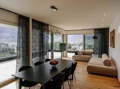 a living room with a table and chairs and a couch at The Hills in Merano