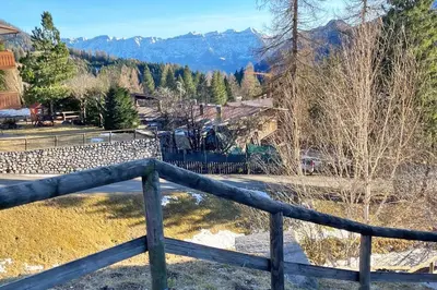 a wooden fence with mountains in the background at Chalet Erika: che vista! in San Martino di Castrozza