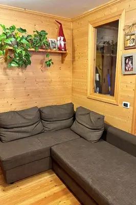 a brown couch in a room with a window at Chalet Erika: che vista! in San Martino di Castrozza