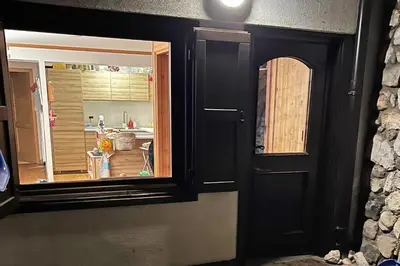 a room with a door and a kitchen with a window at Chalet Erika: che vista! in San Martino di Castrozza