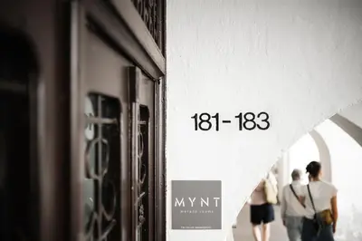 a sign on the side of a building with people walking at Mynt Merano Rooms in Merano