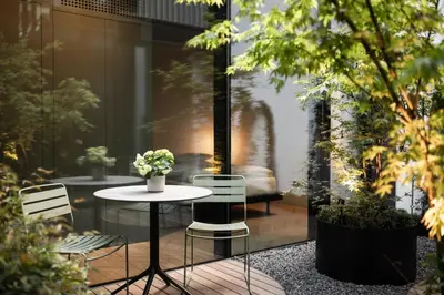 a patio with a table and chairs in a building at Mynt Merano Rooms in Merano