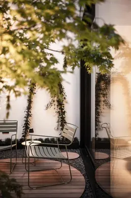 two chairs and a bench sitting on a patio at Mynt Merano Rooms in Merano