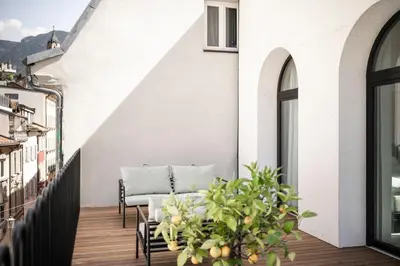 a balcony with a table and chairs on a building at Mynt Merano Rooms in Merano