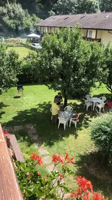 two people sitting under a tree in a yard at CASA PINUCCIA APPARTAMENTO EST in Predazzo