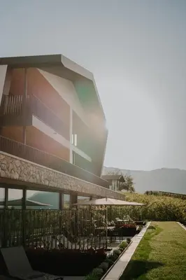 aominium building with a balcony and tables and chairs at Stollhof in Lagundo