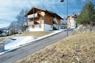 a building on the side of a road with snow at Cesa Azola in Vigo di Fassa