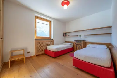 a bedroom with two beds and a window at Cesa Azola in Vigo di Fassa