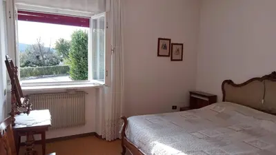 a bedroom with a bed and a large window at Casa vacanze a Romeno in Romeno