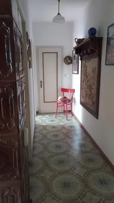 a hallway with a red table and a red chair at Casa vacanze a Romeno in Romeno