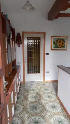 a kitchen with a door and a tile floor at Casa vacanze a Romeno in Romeno