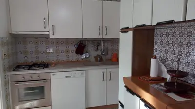 a kitchen with white cabinets and white appliances at Casa vacanze a Romeno in Romeno