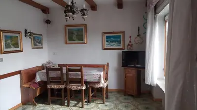 a dining room with a table and chairs at Casa vacanze a Romeno in Romeno