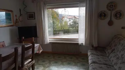 a living room with a couch and a window at Casa vacanze a Romeno in Romeno