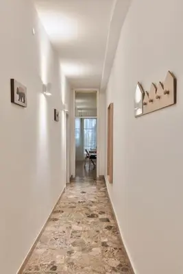 a hallway with white walls and a tile floor at Lauben Studio Bolzano in Bolzano