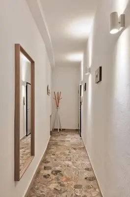 a hallway with white walls and a mirror on the wall at Lauben Studio Bolzano in Bolzano