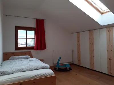 a bedroom with a bed and a red window at Zirbentraum in Lana