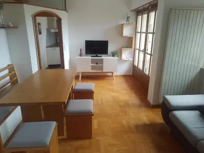 a living room with a table and a television at Zirbentraum in Lana