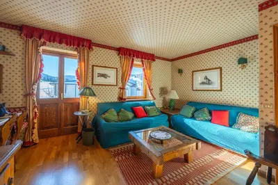 a living room with a blue couch and a table at Casa Allegra, con balcone panoramico in San Vito di Cadore