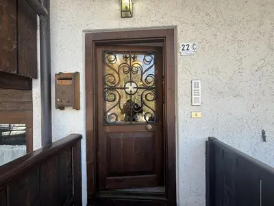 a wooden door with a wrought iron design on a building at Casa Allegra, con balcone panoramico in San Vito di Cadore