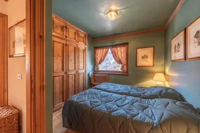 a bedroom with two beds and a window at Casa Allegra, con balcone panoramico in San Vito di Cadore