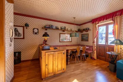 a kitchen with a table and chairs in a room at Casa Allegra, con balcone panoramico in San Vito di Cadore