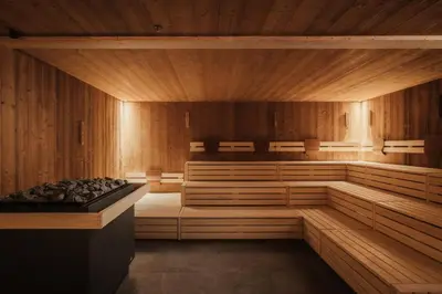 a sauna with wooden walls and a stove in it at Hotel Tofana Cortina in Cortina dʼAmpezzo
