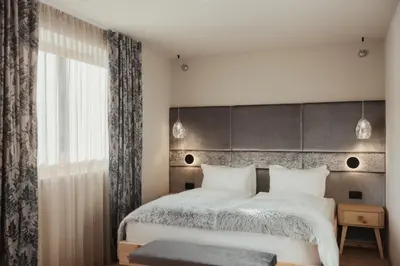 a bedroom with a large bed and a window at Hotel Tofana Cortina in Cortina dʼAmpezzo