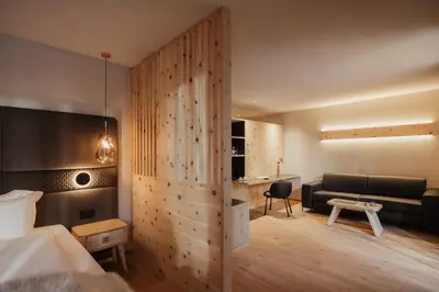 a hotel room with a bed and a couch at Hotel Tofana Cortina in Cortina dʼAmpezzo