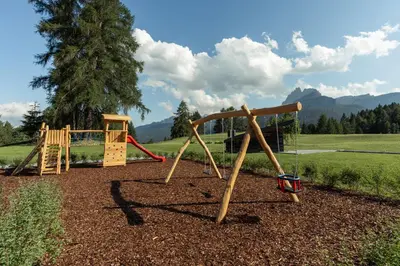 a park with a playground with a swing at Hotel Tofana Cortina in Cortina dʼAmpezzo