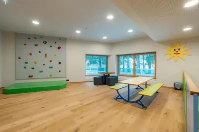 a room with a climbing wall and a table and chairs at Hotel Tofana Cortina in Cortina dʼAmpezzo