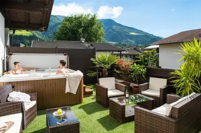 a man and a woman in a hot tub on a patio at Pension Astoria in Naturno