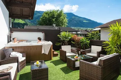 two people in a hot tub on a patio at Pension Astoria in Naturno