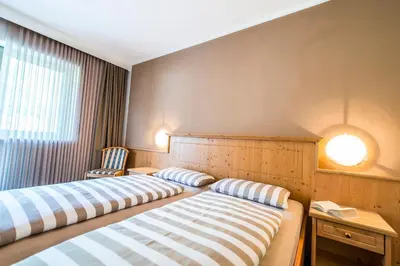two beds sitting in a room with a window at Pension Astoria in Naturno