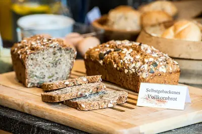 a wooden cutting board with bread on a table at Pension Astoria in Naturno