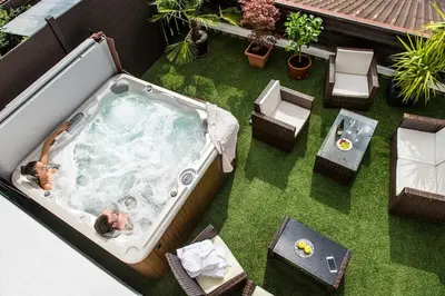 a woman in a jacuzzi tub on a lawn at Pension Astoria in Naturno