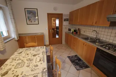 a kitchen with a table and a counter top at Appartamenti Ciasa Molin in Soraga