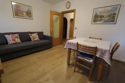 a living room with a table and a couch at Appartamenti Ciasa Molin in Soraga