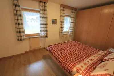 a bedroom with a bed and a window at Appartamenti Ciasa Molin in Soraga