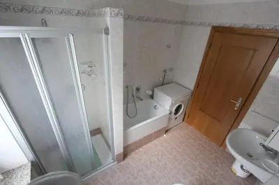 a bathroom with a shower and a toilet and a sink at Appartamenti Ciasa Molin in Soraga
