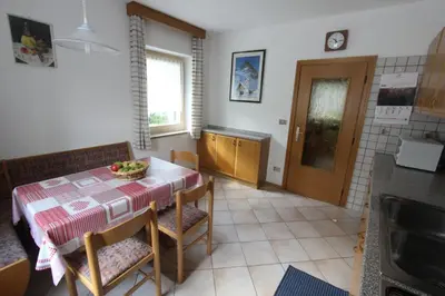 a kitchen with a table with a bowl of fruit on it at Appartamenti Ciasa Molin in Soraga