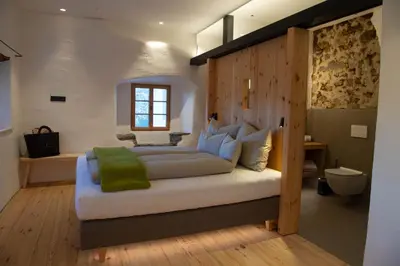 a bedroom with a large bed with a wooden headboard at Steidacherhof in Longomoso