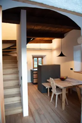 a dining room and kitchen with a wooden table at Steidacherhof in Longomoso
