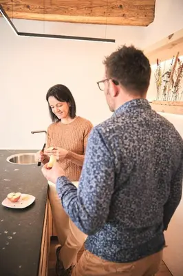 a man and woman standing in a kitchen preparing food at Steidacherhof in Longomoso