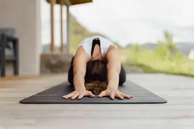 a woman doing a push up on a yoga mat at Steidacherhof in Longomoso
